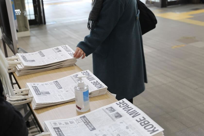 1月17日、JR神戸駅で第1弾である神戸新聞のおみやげ袋が配られている様子。JR 三ノ宮駅、神戸空港、阪神・淡路大震災記念 人と防災未来センターなどでも配布された。